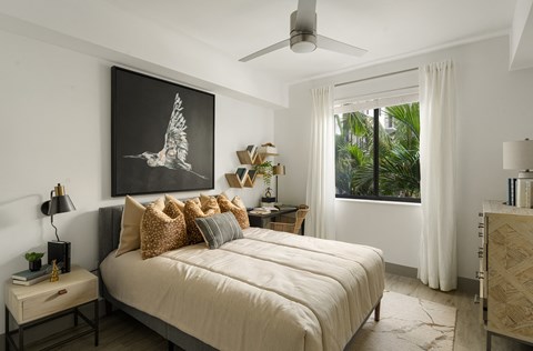 a bedroom with a large bed and a painting of a bird